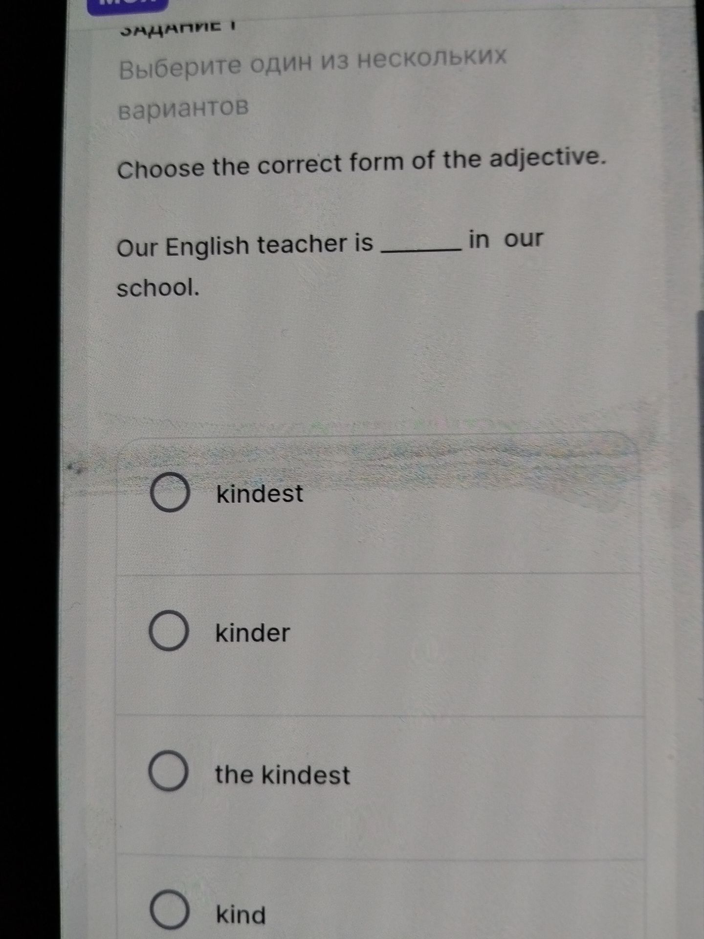 Фото задания: Choose the correct form of the adjective. Our English teacher is ______ in our school.