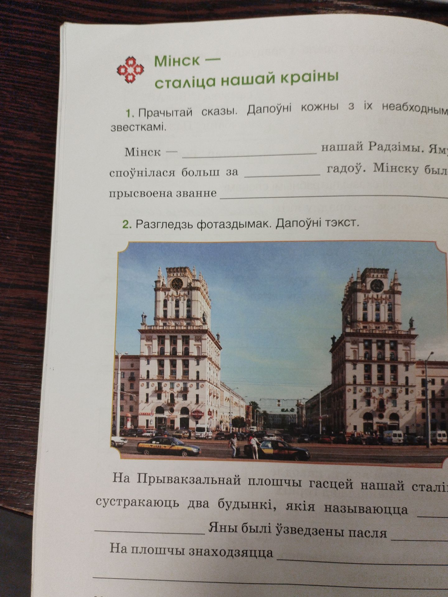 Фото задания: 2. Разгледзь фотаздымак. Дапоўні тэкст. На Прывакзальнай плошчы гасцей нашай сталіцы сустракаюць два будынкі, якія называюцца…