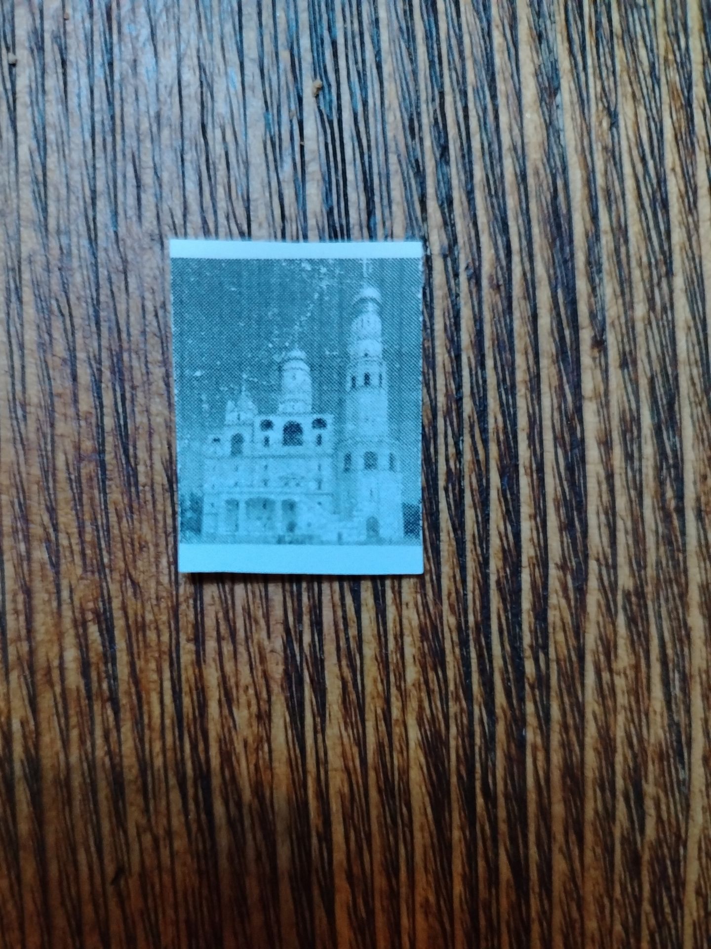 Фото задания: This image contains a small, faded black and white picture of a building with towers and arched windows. What is this…