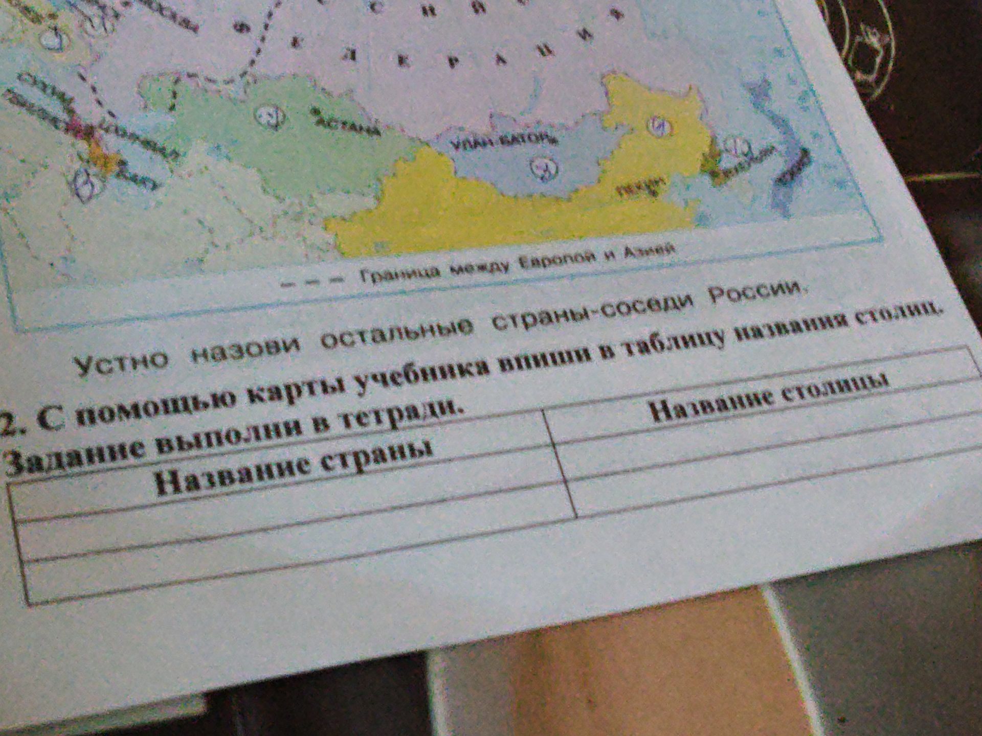 Фото задания: Устно назови остальные страны-соседи России. 2. С помощью карты учебника впиши в таблицу названия столиц. Задание выполни в…