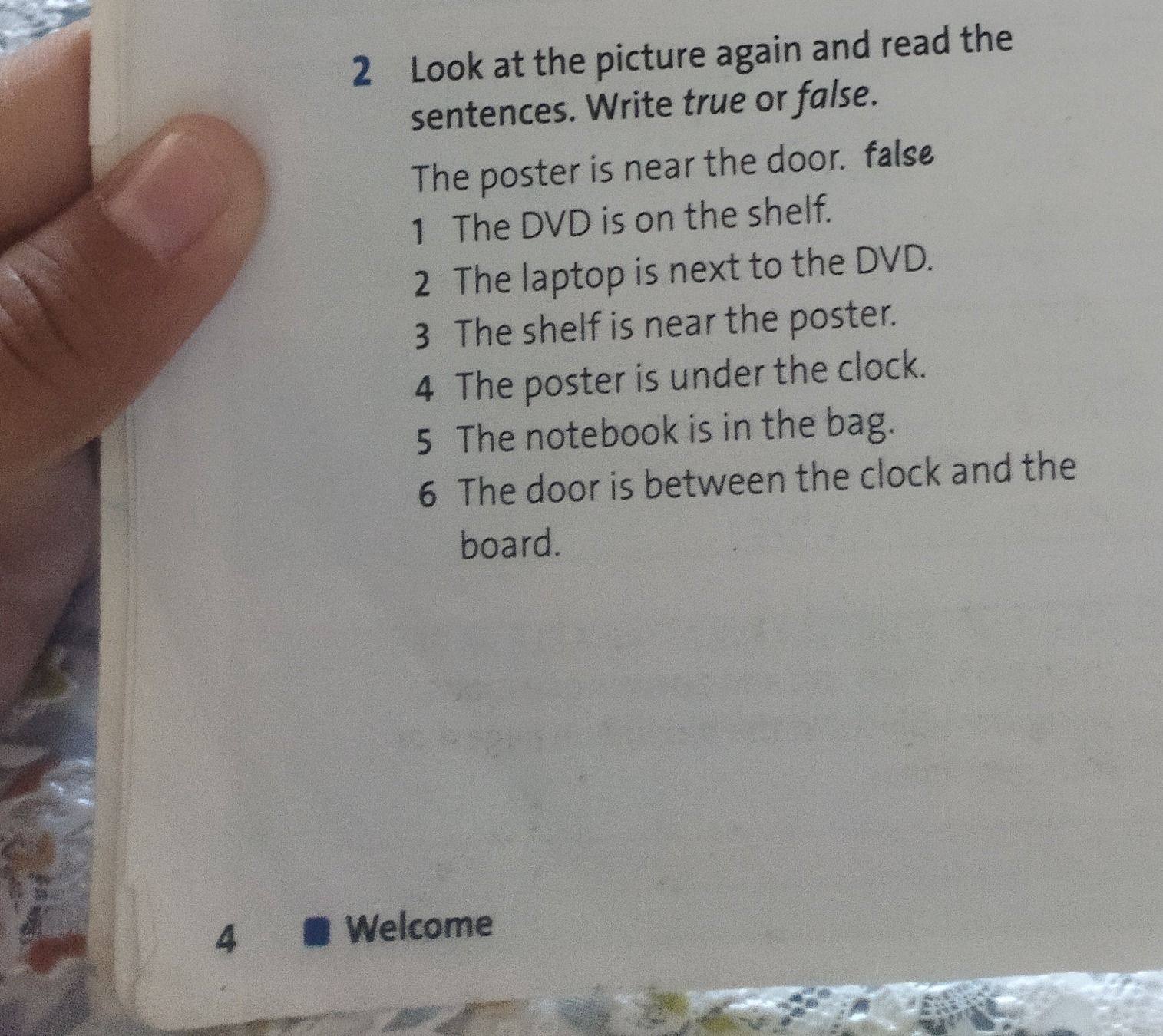 Фото задания: Look at the picture again and read the sentences. Write true or false. The poster is near the door. 1) The DVD is on the…