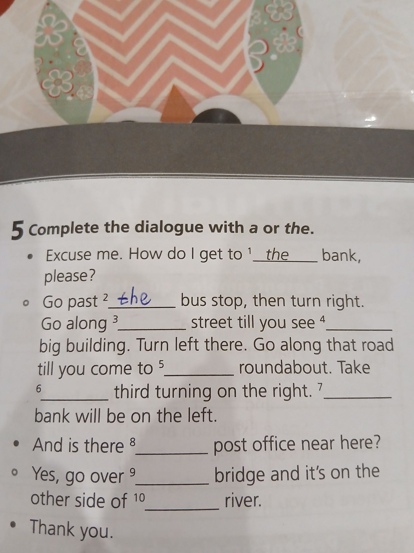 Фото задания: Complete the dialogue with a or the: Excuse me. How do I get to ___ bank, please? Go past ___ bus stop, then turn right. Go…