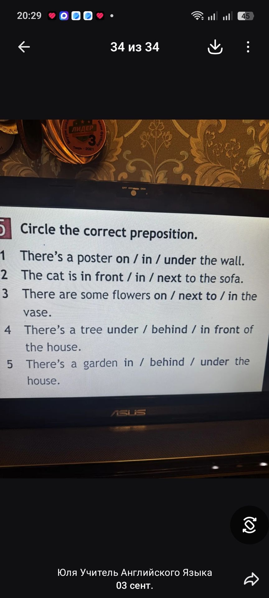 Фото задания: Circle the correct preposition. 1. There’s a poster on / in / under the wall. 2. The cat is in front / in / next to the sofa.…