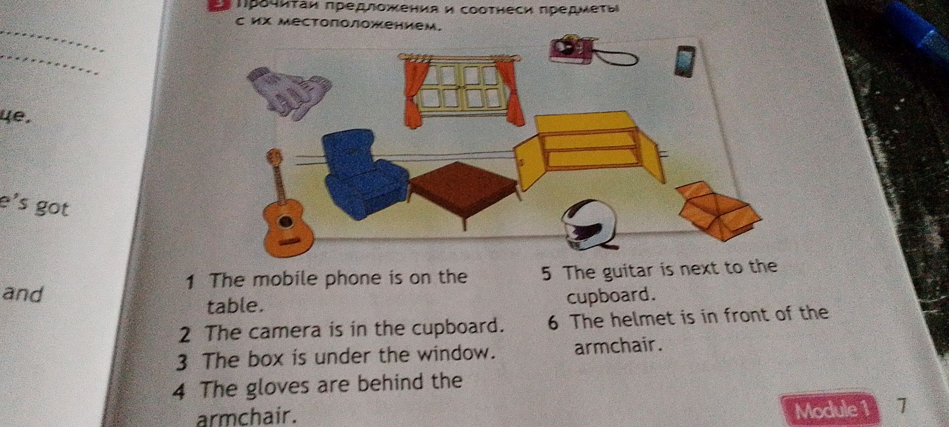 Фото задания: 1. The mobile phone is on the table. 2. The camera is in the cupboard. 3. The box is under the window. 4. The gloves are…