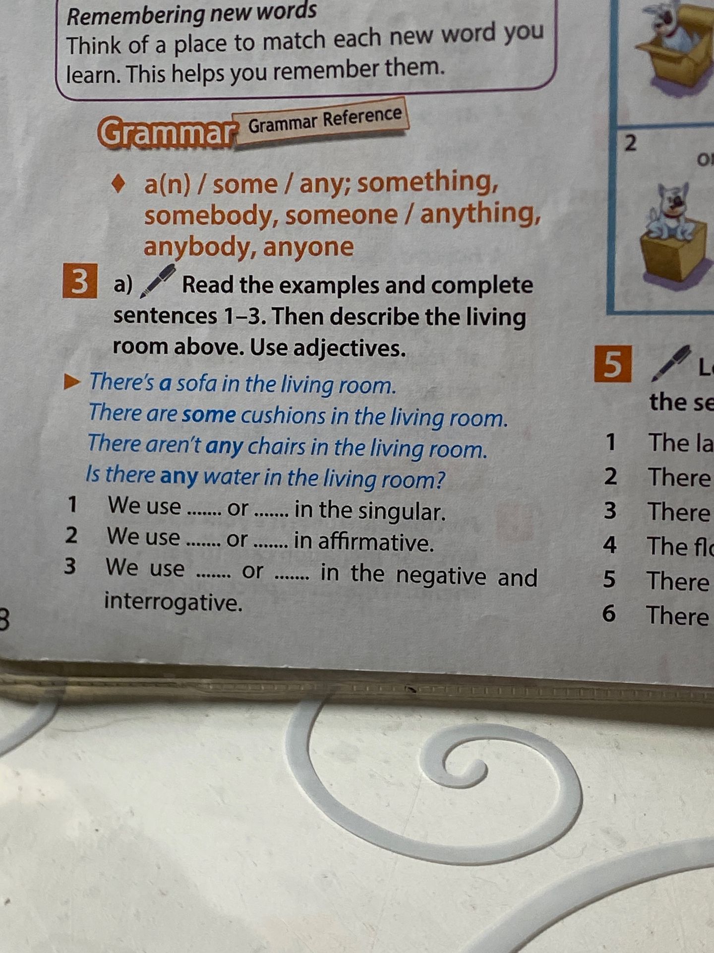 Фото задания: 3 a) Read the examples and complete sentences 1–3. Then describe the living room above. Use adjectives. There’s a sofa in the…