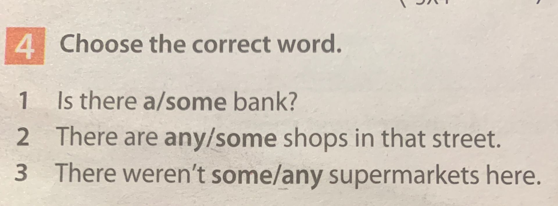 Фото задания: 4. Choose the correct word. 1) Is there a/some bank? 2) There are any/some shops in that street. 3) There weren’t some/any…