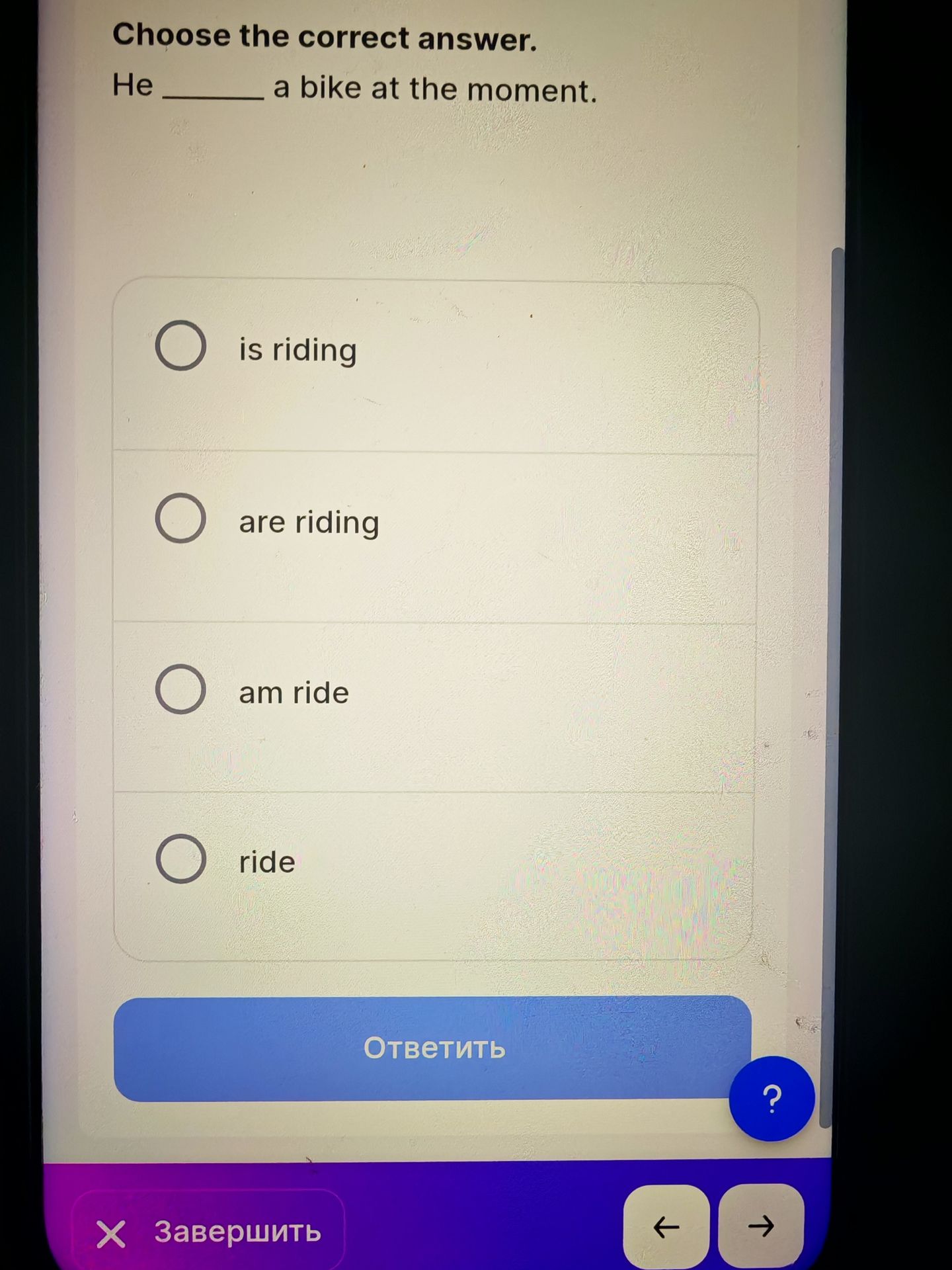 Фото задания: Choose the correct answer. He _____ a bike at the moment. (is riding / are riding / am ride / ride)